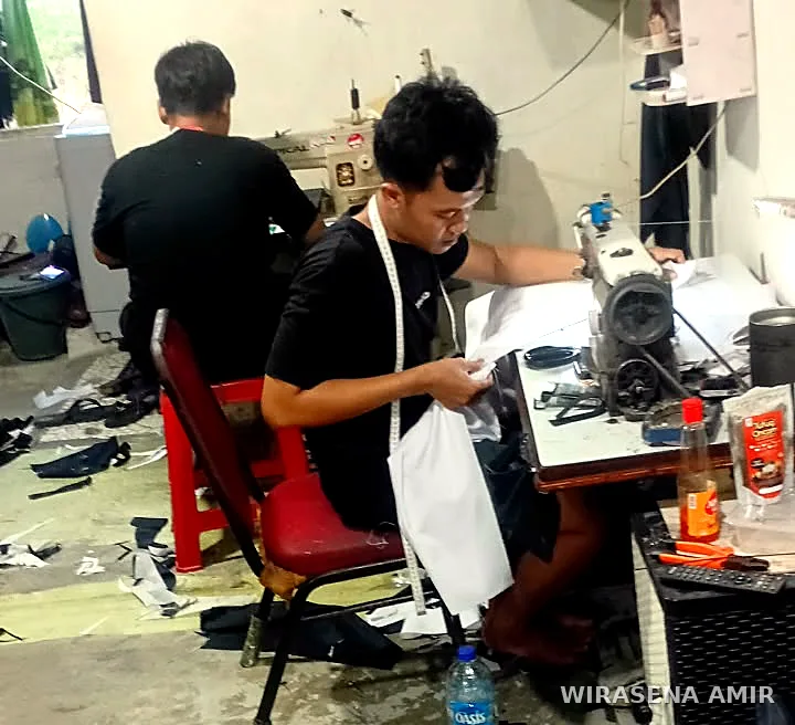 Penjahit Wirasena Amir menjahit di ruang produksi konveksi