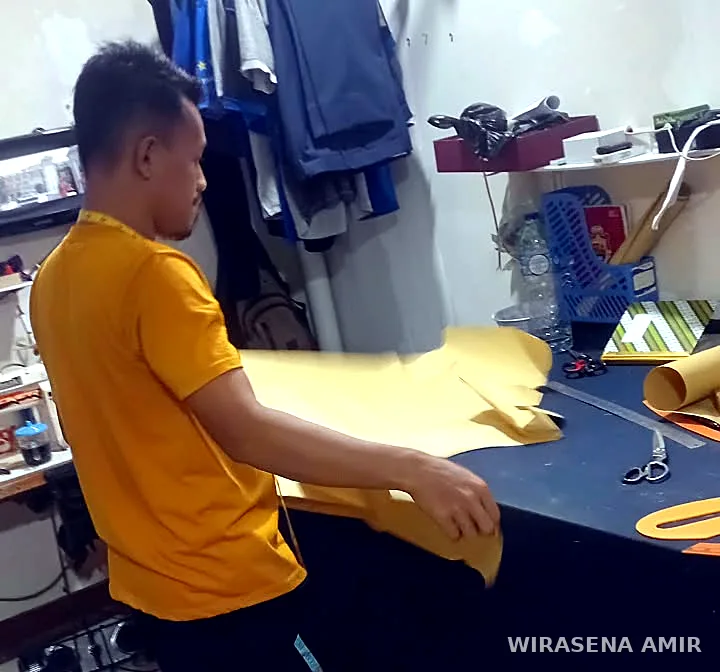 Pemotongan pola kain di meja potong konveksi