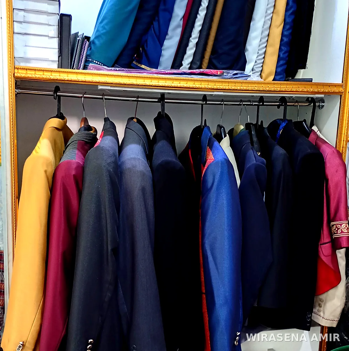 Rak jas custom dan gulungan bahan kain di toko